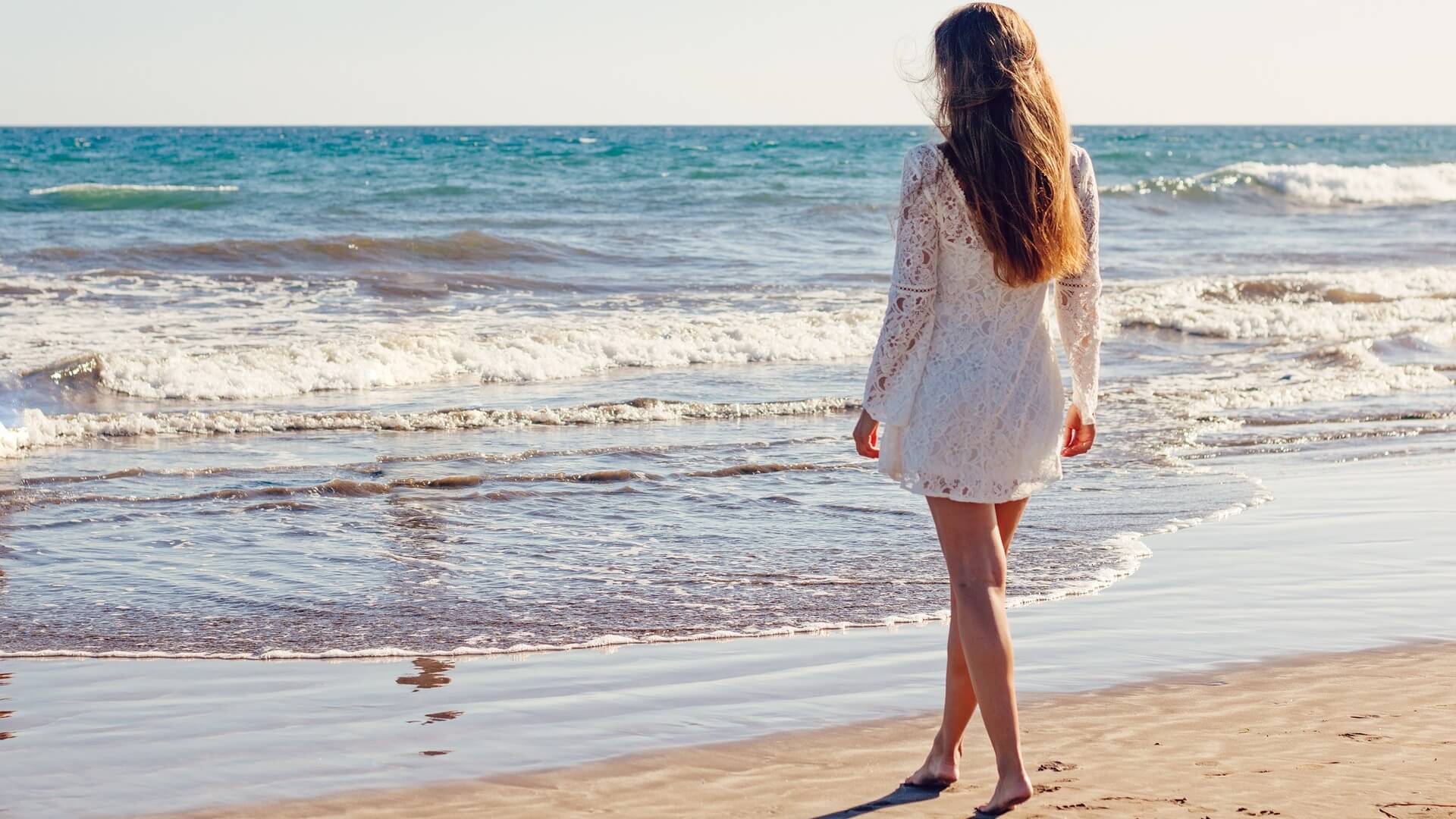 mujer caminando en la playa